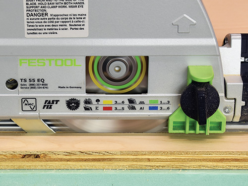 Close-up of a track saw making a cut through a panel