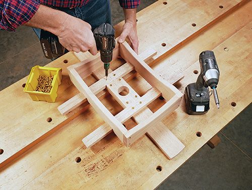 Screwing parts of Adirondack table assembly together