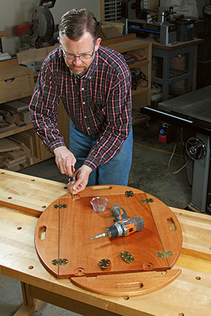 Installing hinges on each of the four tray wings