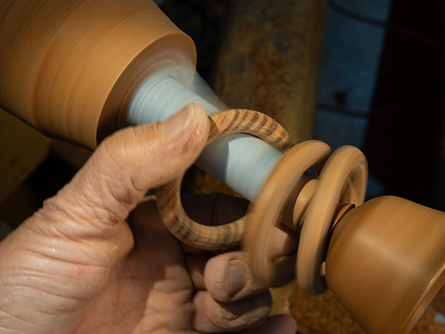Sanding interior of turned rings with sandpaper wrapped goblet stem
