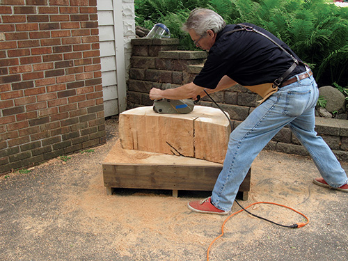 Taking down cottonwood table top with a belt sander