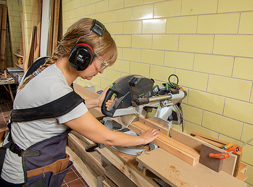 Cutting potter's bench cedar to length with miter saw