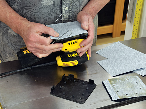 Attaching a quarter sheet of sandpaper to an orbit sander