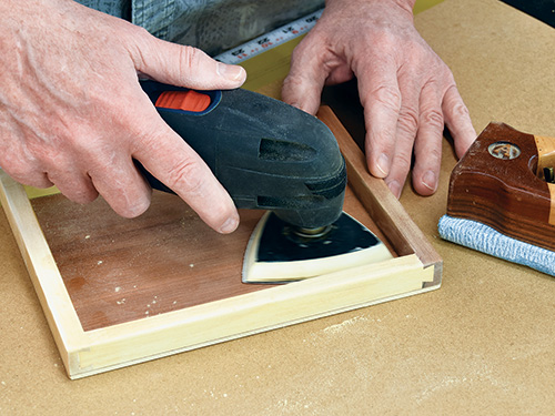 Smoothing out project corner with a triangular detail sander