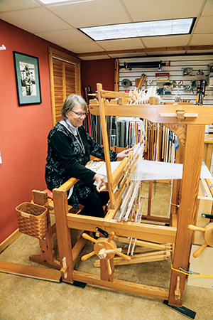 Susan Conover demonstrating the operation of a loom