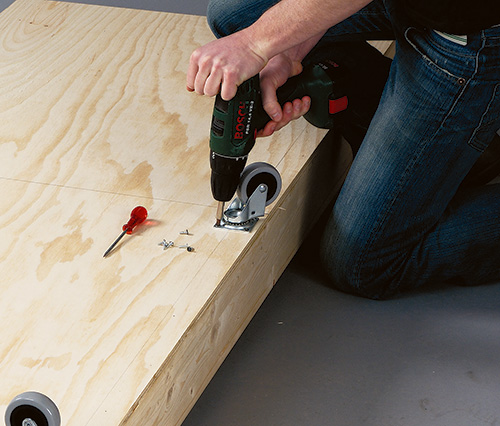 Installing casters to the base of coffee table bed