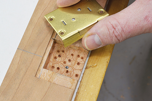 Rub pencil on the end of the key post, and press the lock into place to mark the mortise for drilling the keyhole.