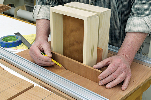 To set up the locations for the dadoes for the drawer openings, it’s easiest to use the drawers themselves as a guide. Note here that the author uses scrap of the same thickness as the drawer shelves as spacers.