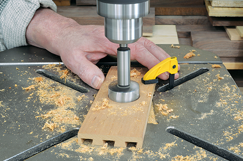 large Forstner bit makes the initial round mortise for the flush pull. Do a test cut in scrap, and set the drill press depth stop appropriately.