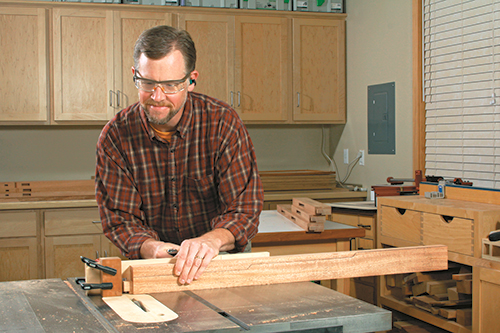 Raise tenons on the top ends of the legs before you cut their contoured edges, while the workpiece edges are still flat. A dado blade, miter gauge and stop block make this process quick and accurate.