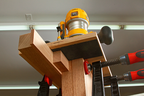 Adding a 1/4" -thick shim and stop block enabled the same leg mortising jig to produce the rail mortises, too.