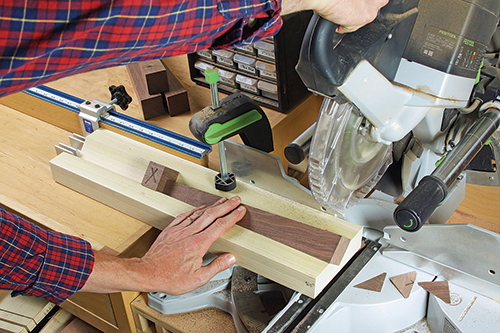 A scrap V-groove jig can hold the legs securely while you trim their top and bottom ends to 5.5° at the miter saw. The author used CA glue to fix a stop block in the jig's groove. It ensured matching leg lengths.