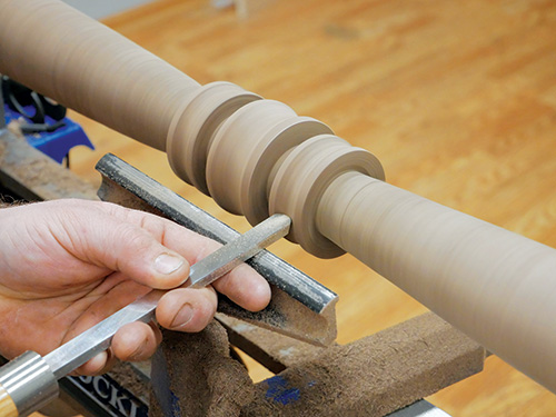 Using spindle gouge to finish cutting decorative rings on plant stand