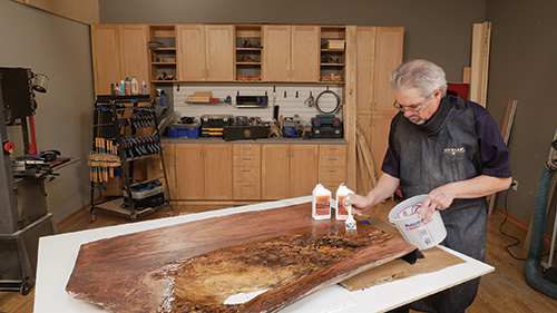 Brushing epoxy sealer onto maple slab tabletop