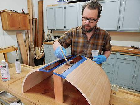 Mask off the doors around the trim strips and then apply epoxy to just the strips, using a brushing technique instead of pouring.