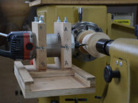 Router jig attached to lathe to cut turned blanks on a lathe