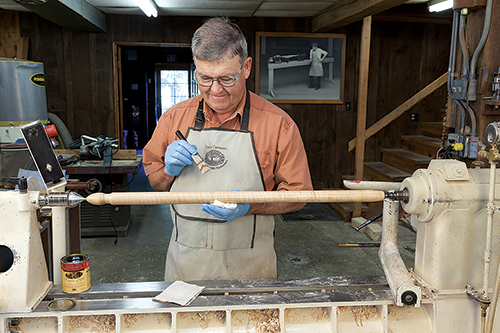 Applying finish to chair legs on a lathe