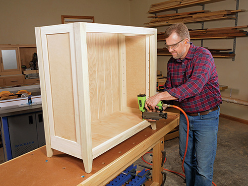 Nailing bottom panel of cabinet in place