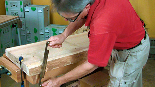 Scraping the sides of natural-edged lumber