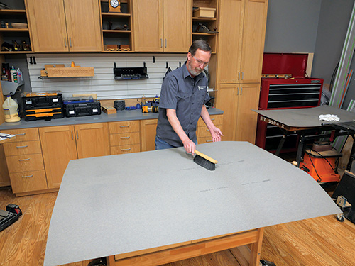 Wiping down laminate sheet with brush