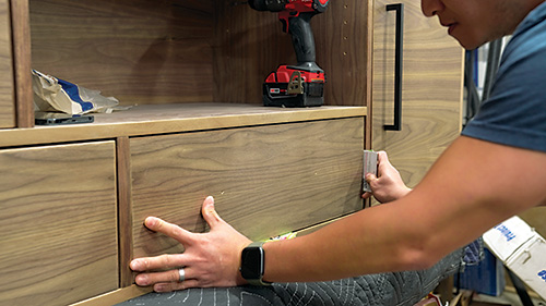 Placing drawer in walnut storage cabinet