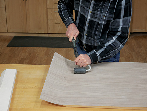 Using roller to firmly apply veneer